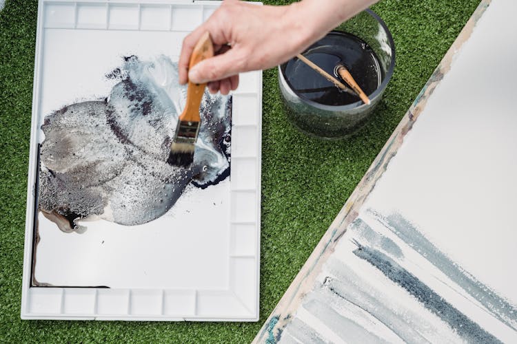 High-Angle Shot Of A Painter Mixing The Color In A Palette