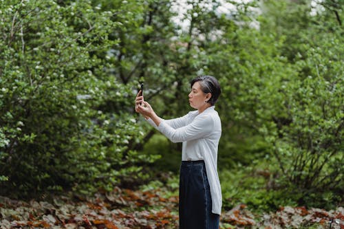 Side View of a Woman Taking Photos Using Her Smartphone
