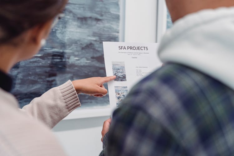 Close-Up Photo Of A Person Pointing Her Finger At The Paper