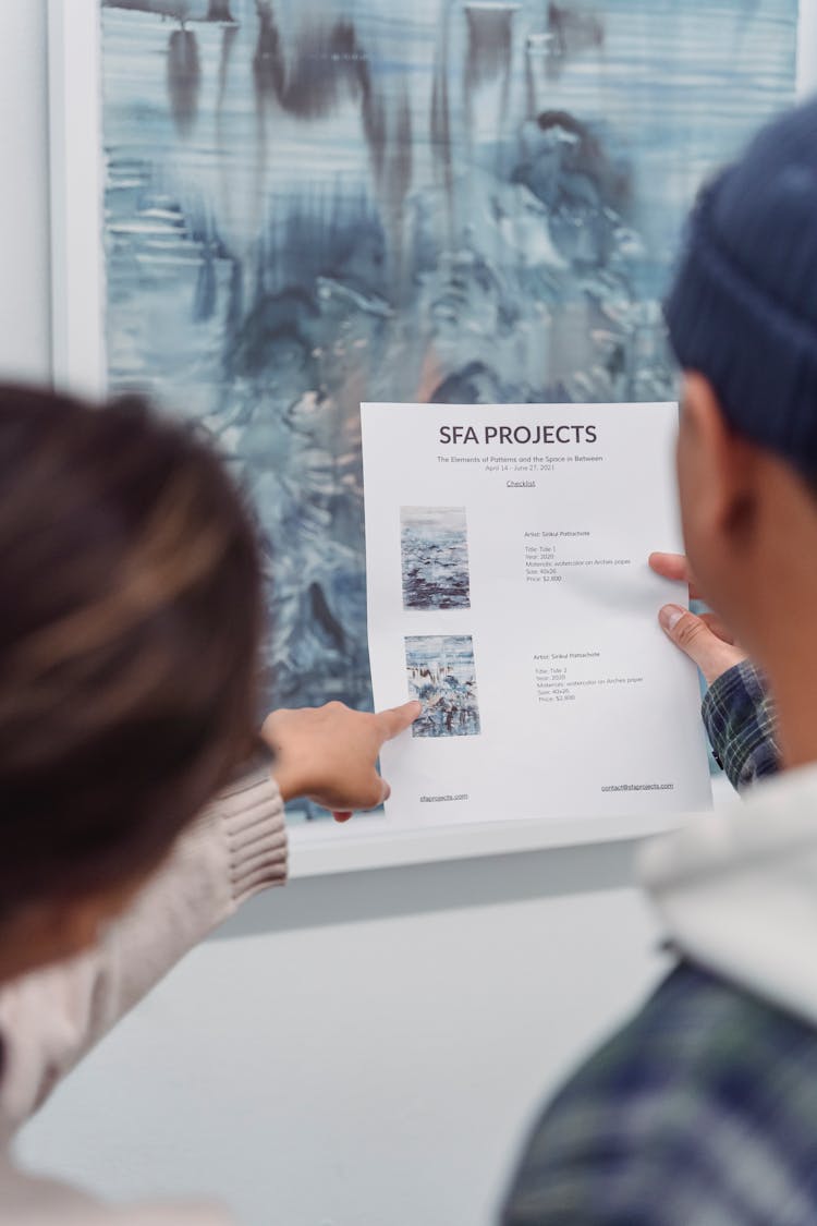 Close-Up Photo Of A Person Pointing Her Finger At The Paper