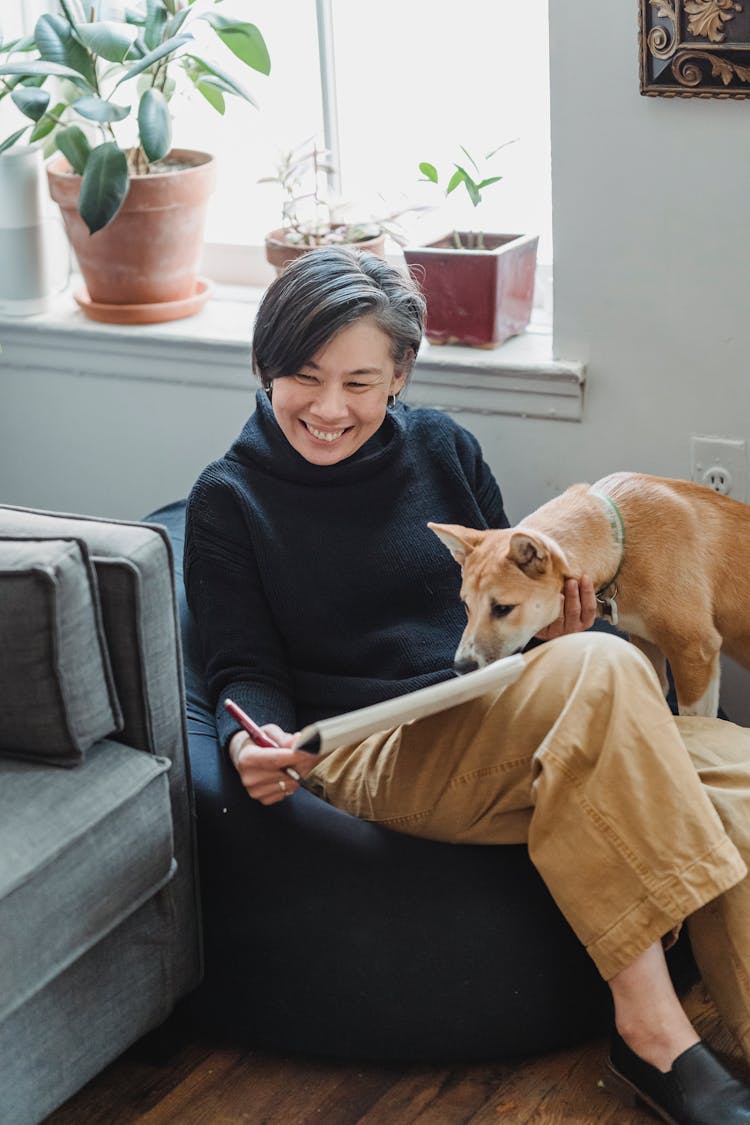 A Woman Laughing With Her Brown Dog