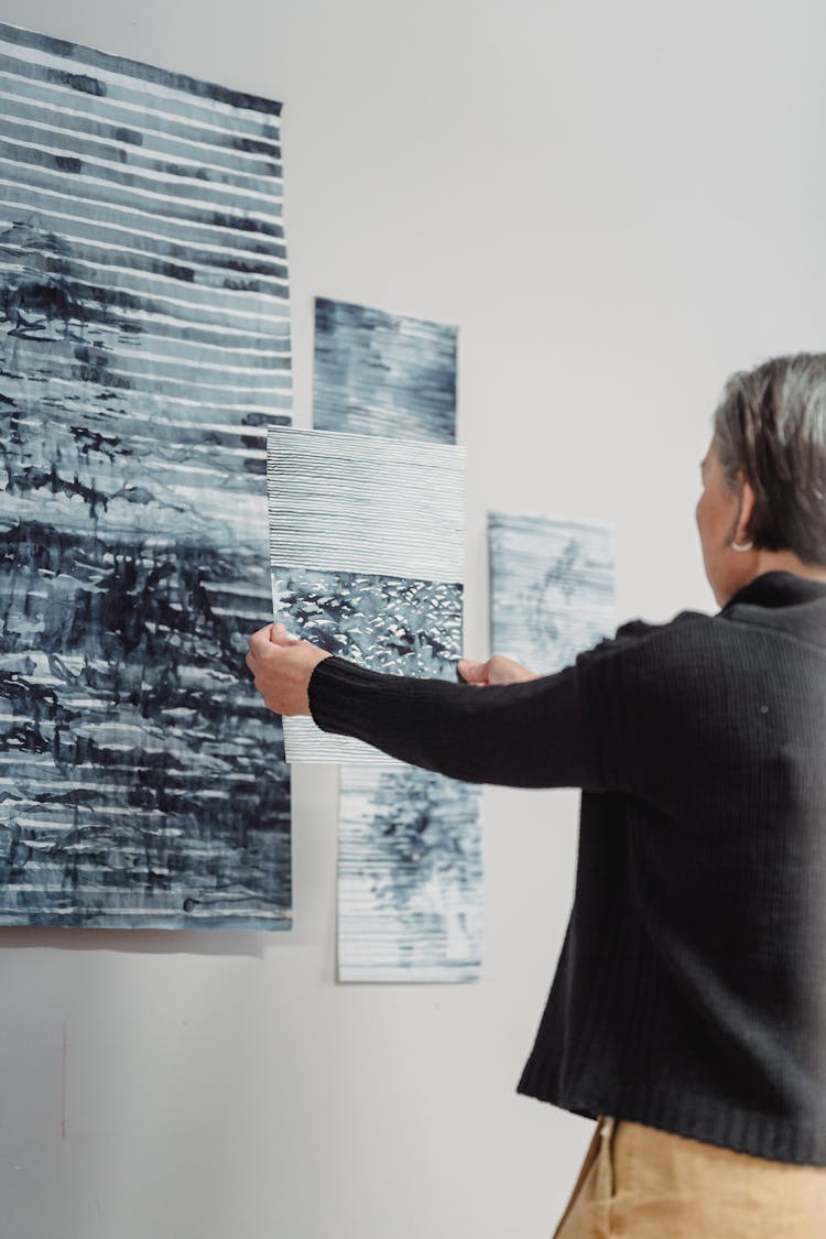 Woman In Black Cardigan Looking At The Abstract Painting