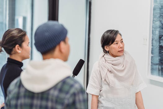 A casual interview with reporters in an indoor setting, featuring microphones and engaged discussion.