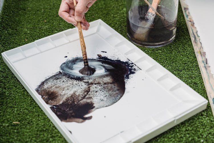 Close-Up Photo Of A Painter Mixing The Color In A Palette