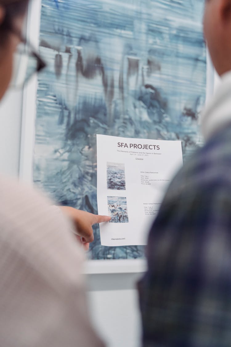 Close-Up Photo Of A Person Pointing Her Finger At The Paper