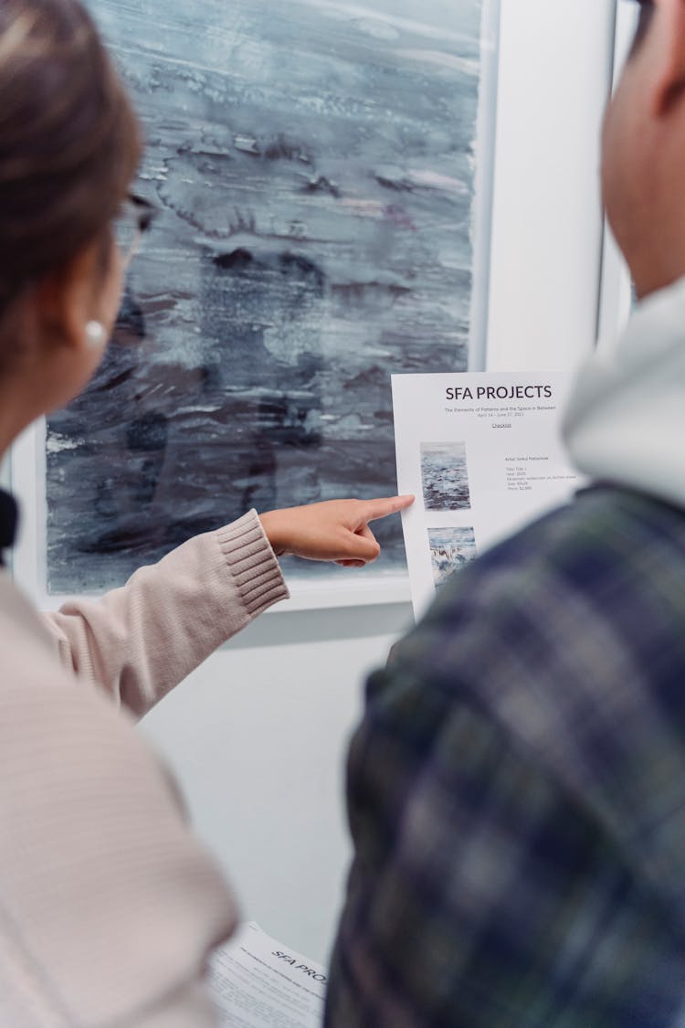 Close-Up Photo Of A Person Pointing Her Finger At The Paper