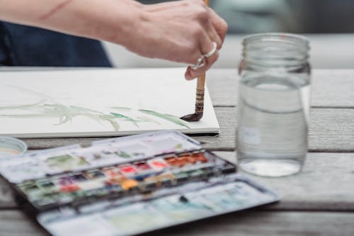 Close-Up Photo of a Person Painting an Artwork