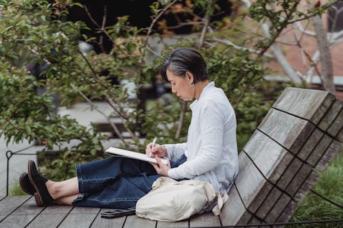 Side View of a Woman Drawing in a Sketchpad