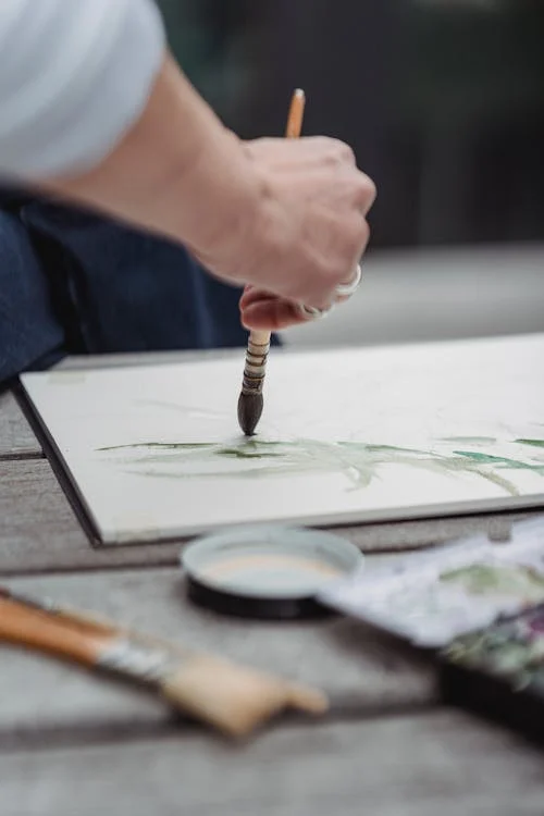 Close-Up Photo of a Person Painting an Artwork