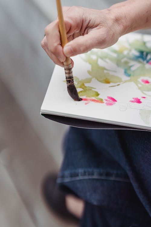 Close-Up Photo of a Person Painting an Artwork