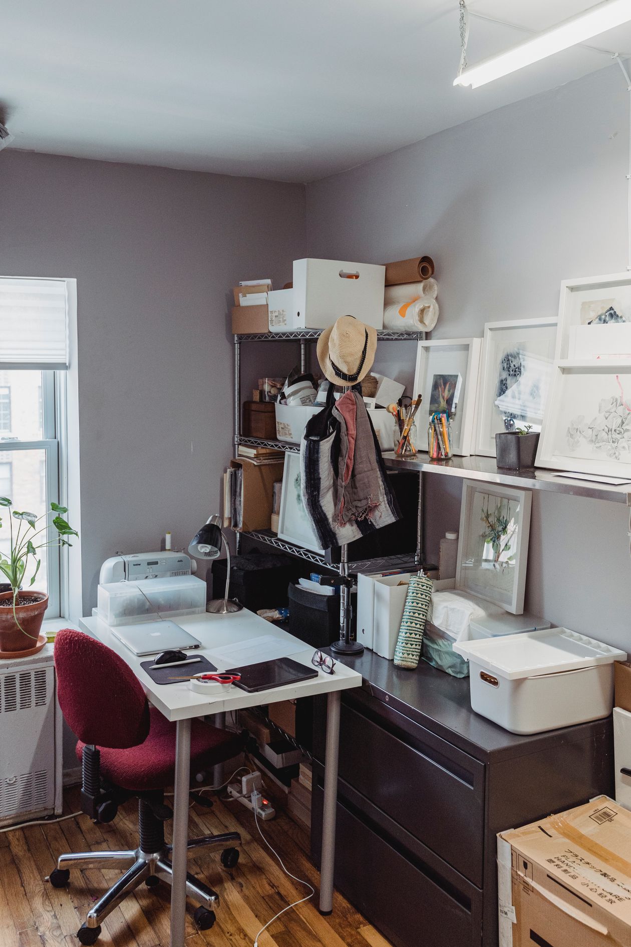 home office with a black wire shelf holding storage bins