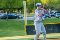 Man in White and Blue Baseball Jersey and White Pants Standing on Green Grass Field during