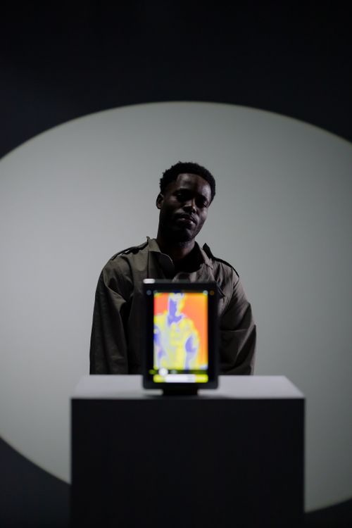 Person holding a tablet that displays a thermal image indoors