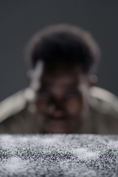 A blurred portrait of a man behind a textured surface in an artistic composition.