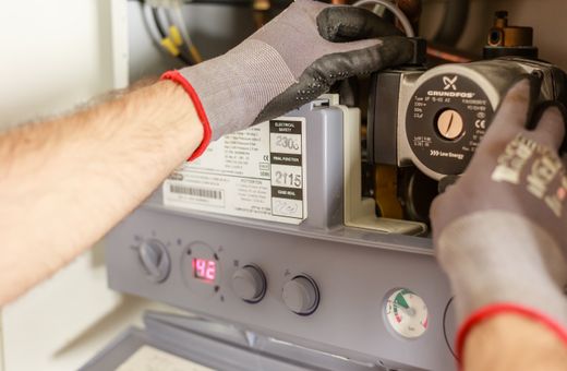 Hands adjusting a home boiler's controls