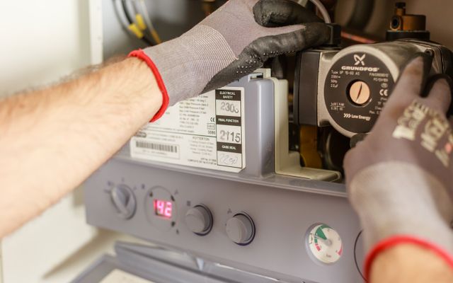 Technician adjusting boiler controls