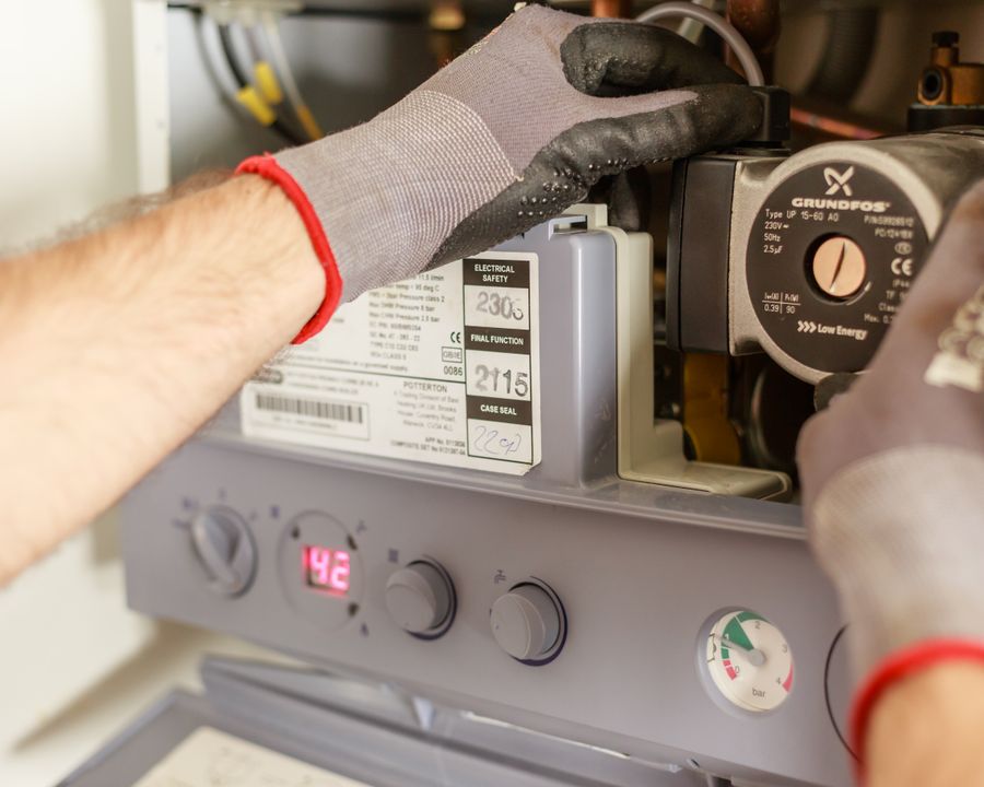Technician adjusting boiler controls