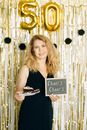 Woman in Black Spaghetti Strap Top Holding Black and White Signage