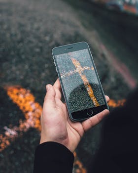 A smartphone showcases a reflection of painted lines on an asphalt surface, capturing artistic street photography.