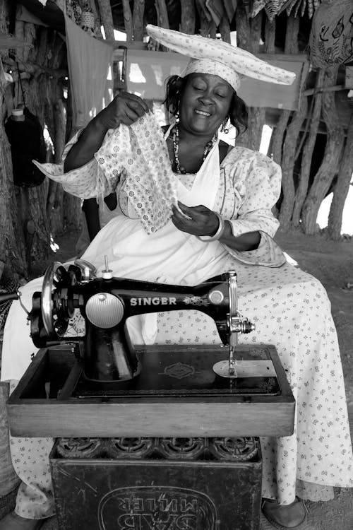 Smiling Woman Using Retro Sewing Machine 