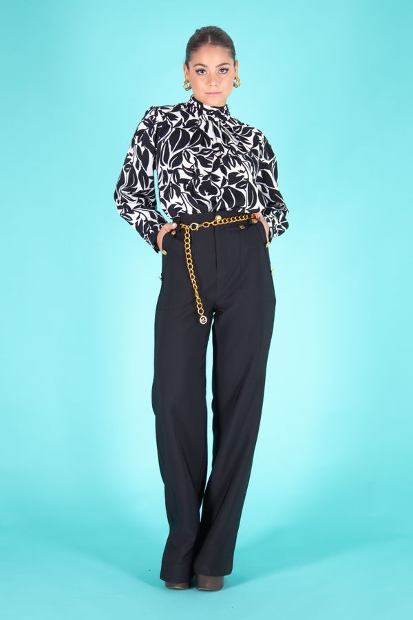 Woman in a high-neck blouse with flowing palazzo pants