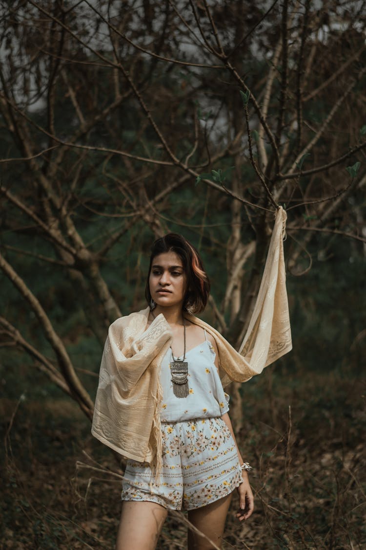 Lady In Boho Clothes Near Leafless Tree