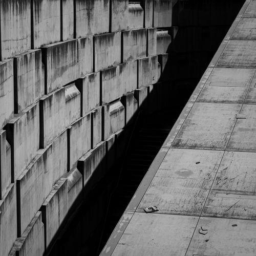 Free Black and white photo showcasing symmetrical concrete architecture with strong geometric patterns and contrasting shadows. Stock Photo