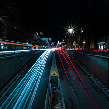 Nighttime city street with vibrant light trails showcasing long exposure photography.