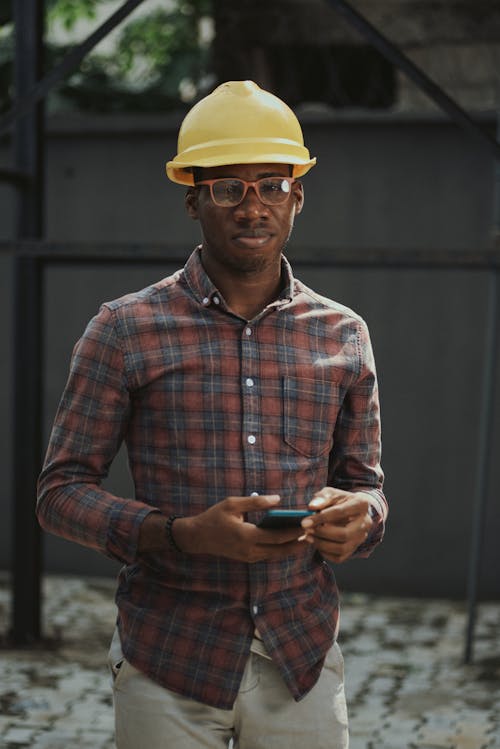Free Man in Plaid Shirt Wearing Hard Hat while Looking at Camera Stock Photo