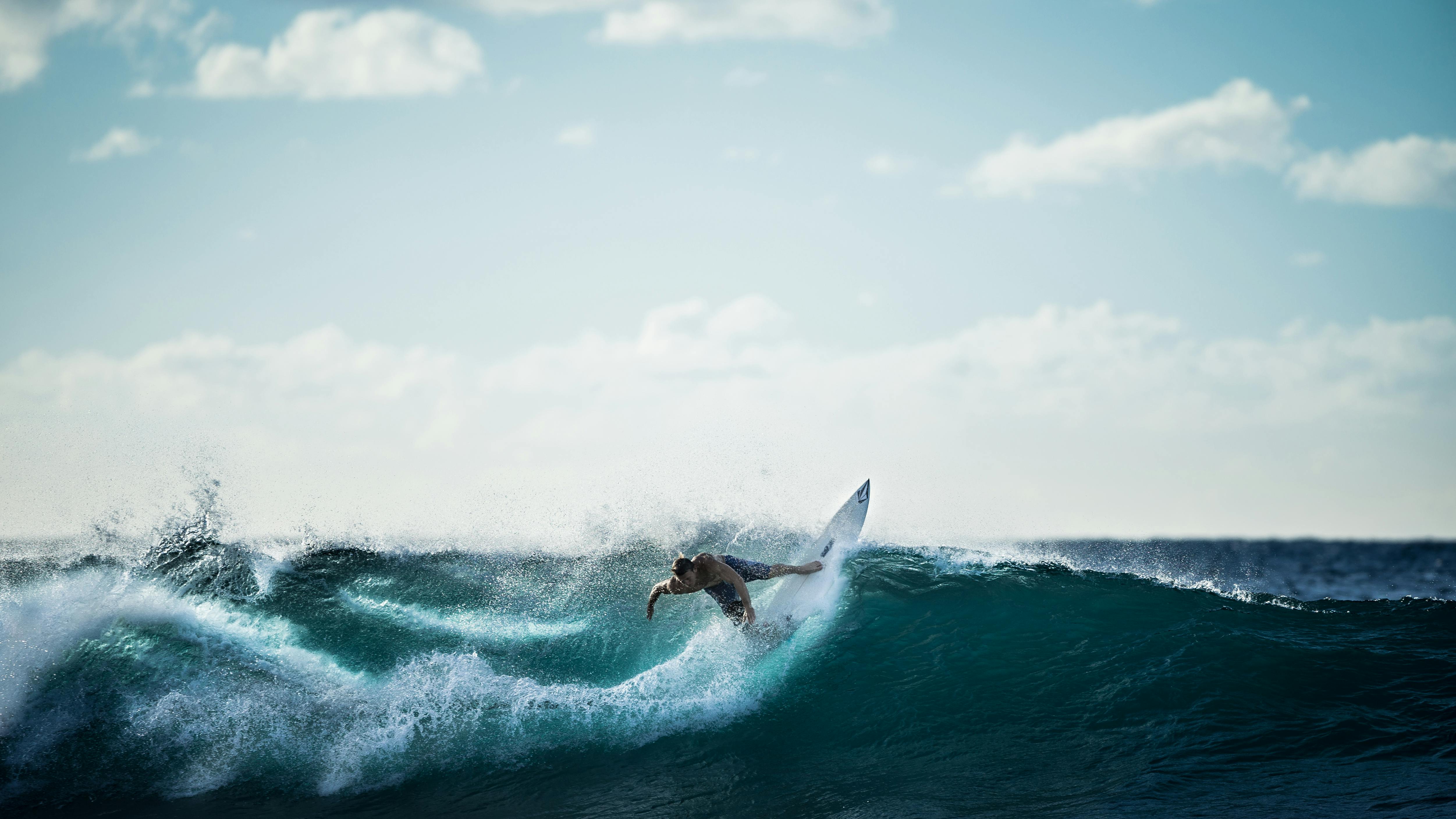 サーフィンをしている白いサーフボードに乗っている人 無料の写真素材