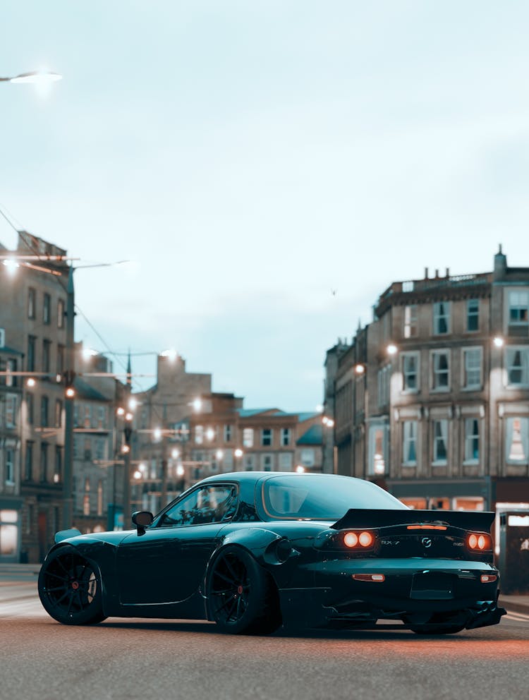 A Black Car Parked On The Street Near Buildings