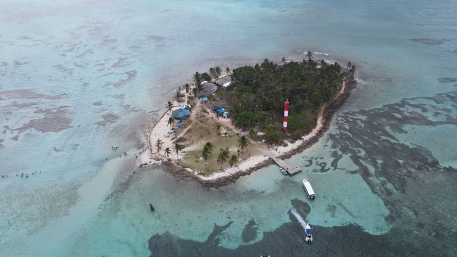 Small boat approaching a pristine beach in the San Blas Islands, Panama
