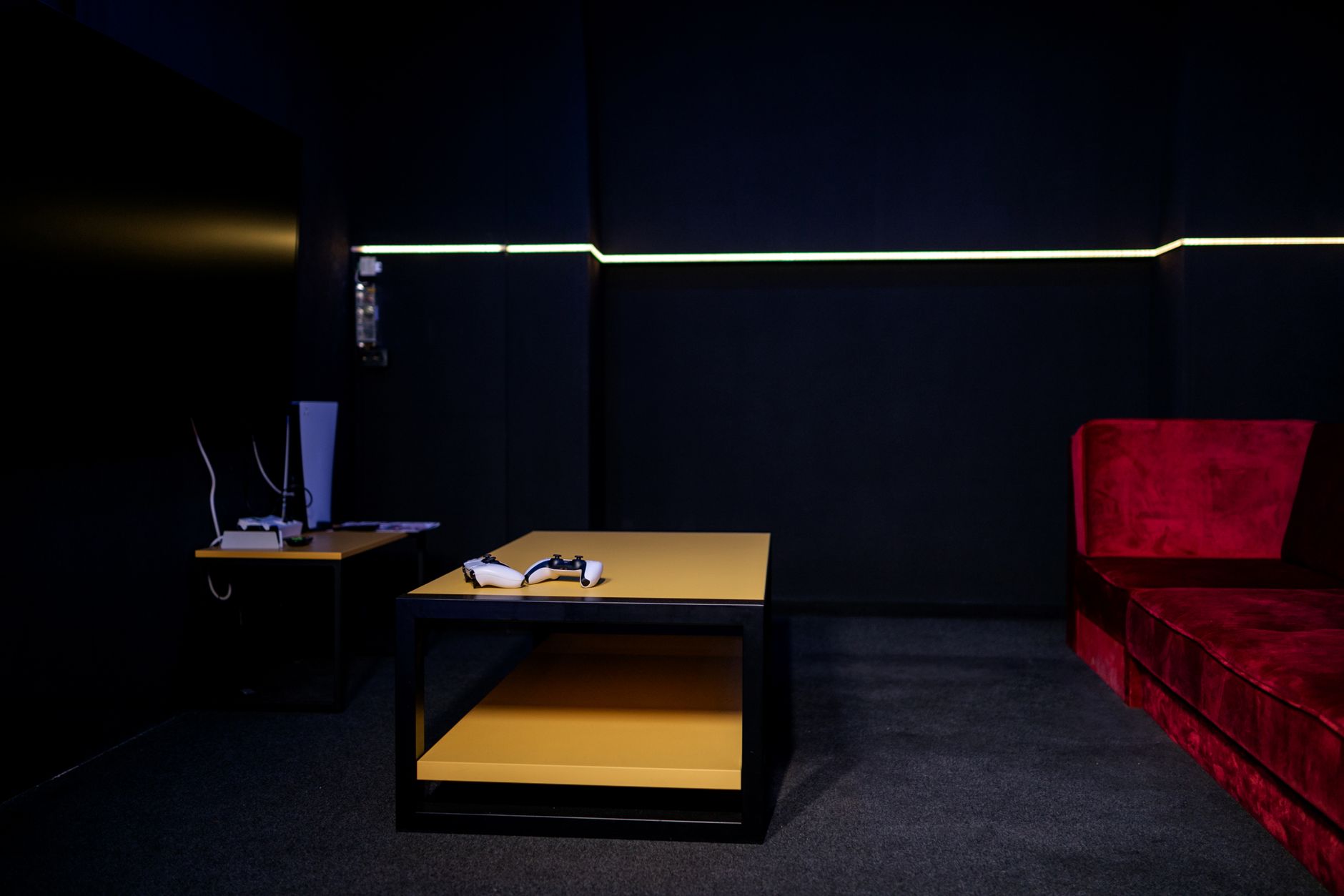 A sleek gaming room featuring controllers and vibrant furniture, ideal for entertainment enthusiasts.