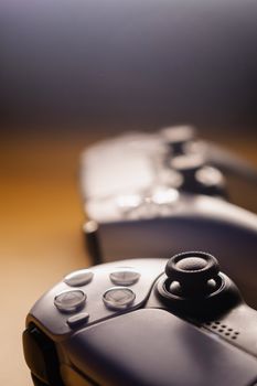 Focused view of sleek game controllers with warm lighting. Ideal for gaming concepts.