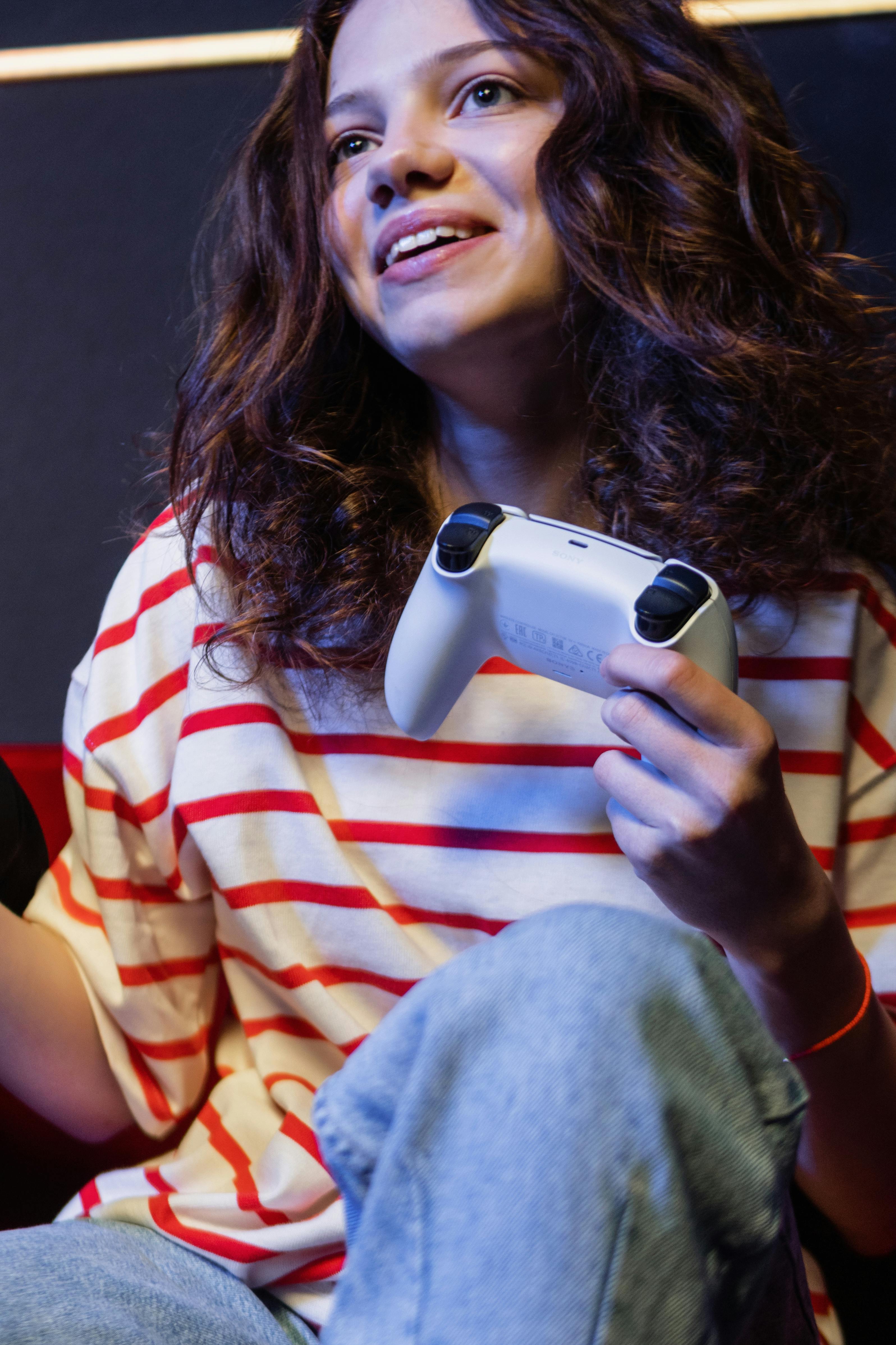 a low angle shot of a woman in striped shirt holding a game controller