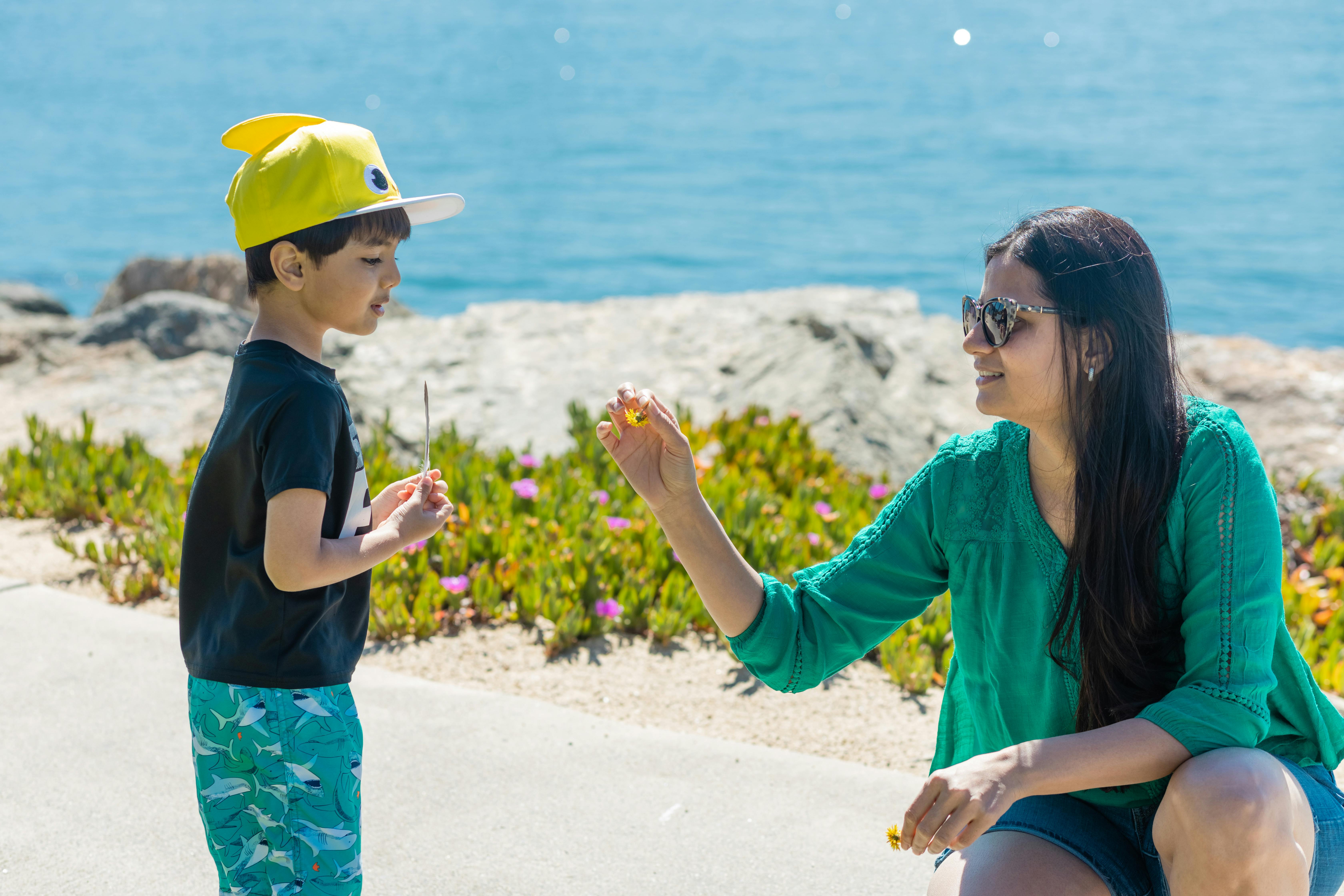 mother and son looking at a flower