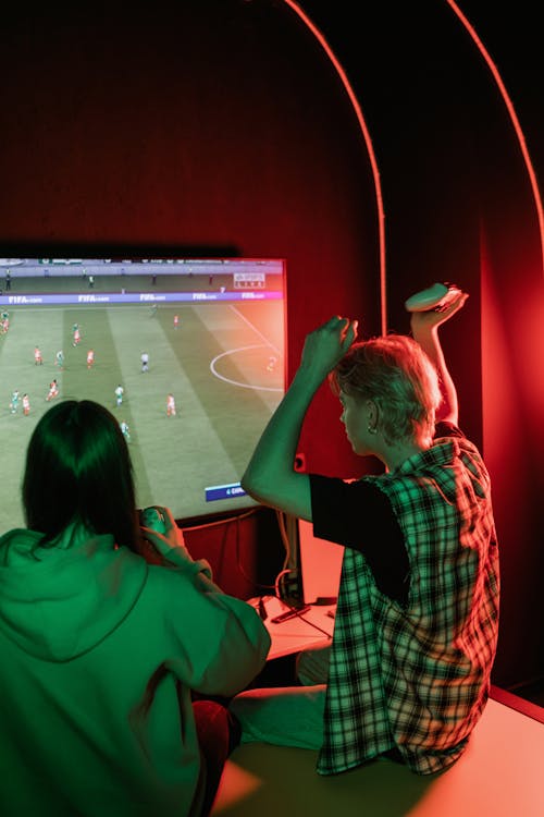 A Man and Woman Sitting while Playing Video Games