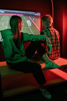 A couple playing video games with controllers in a neon-lit room, enjoying a casual gaming session.