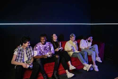 Friends Sitting on the Couch and Holding Game Controllers