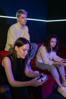 Three young adults absorbed in a video game session on a cozy sofa indoors.