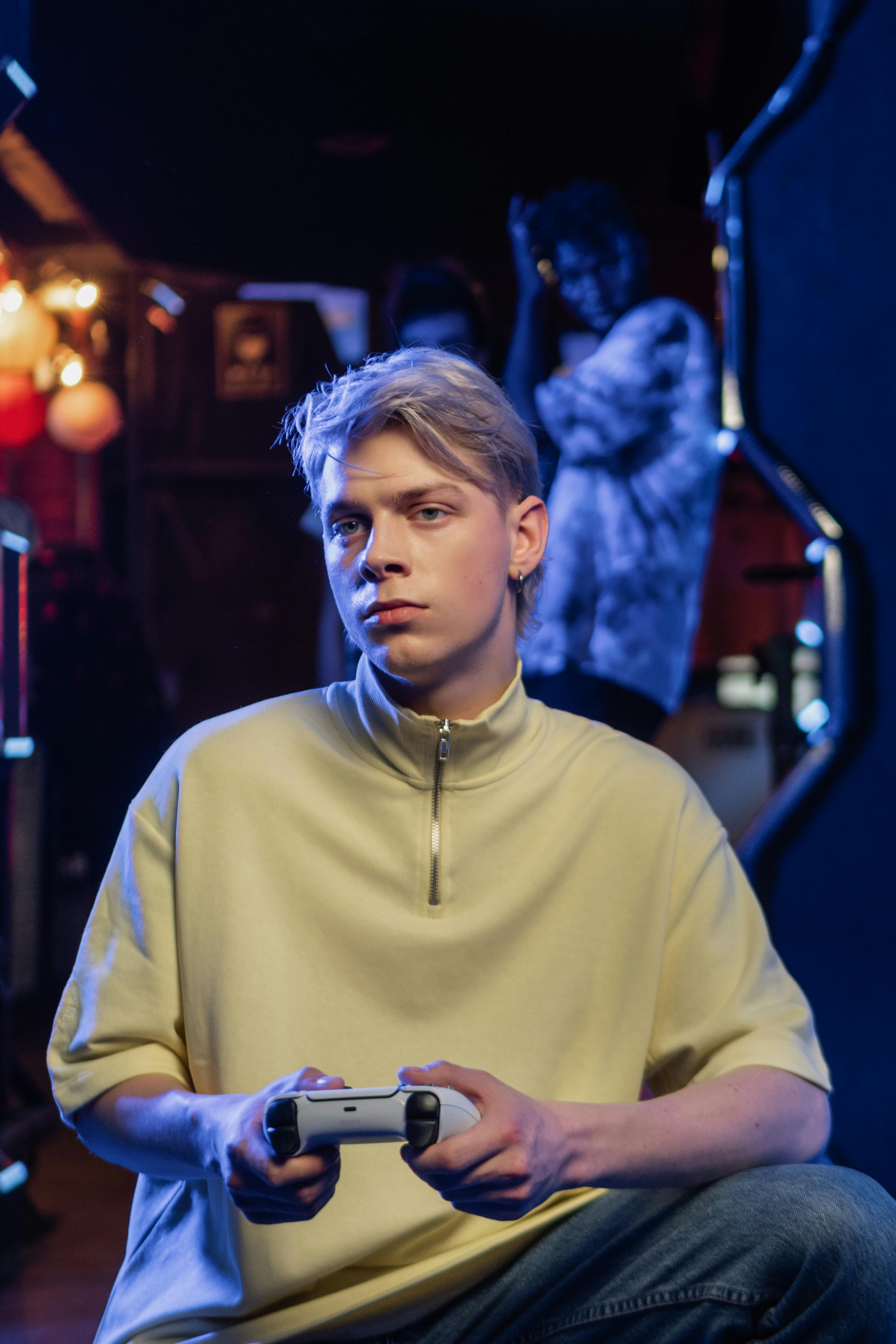 a man in turtle neck shirt holding a game controller