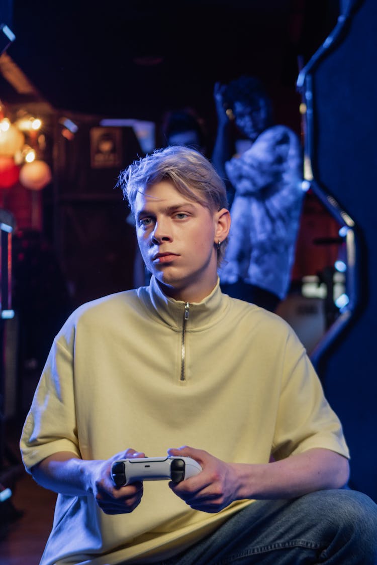 A Man In Turtle Neck Shirt Holding A Game Controller