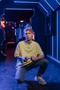 Man in Brown Crew Neck T-shirt and Blue Denim Jeans Sitting on Blue Floor