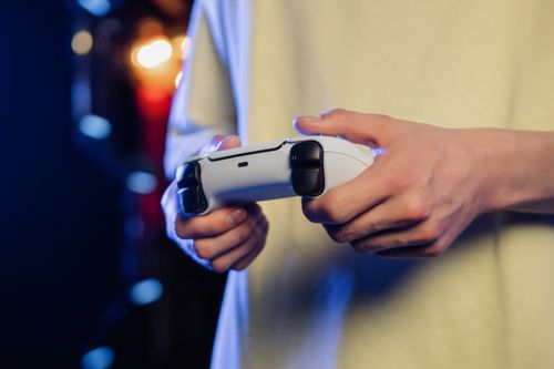 Free Hands gripping a game controller, displaying focus during an intense gaming session. Stock Photo