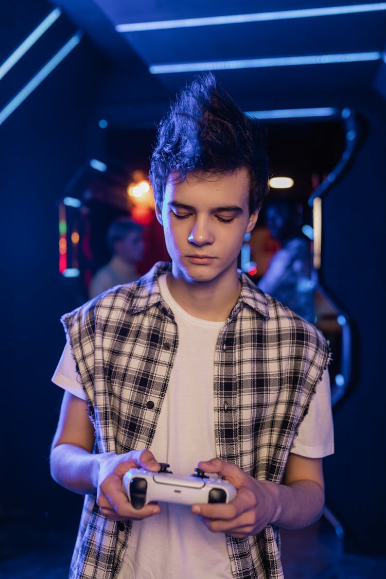 A Young Man Wearing Vest While Holding A Game Controller