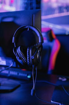 Stylish gaming headset hanging on a computer monitor in a vibrant setup.