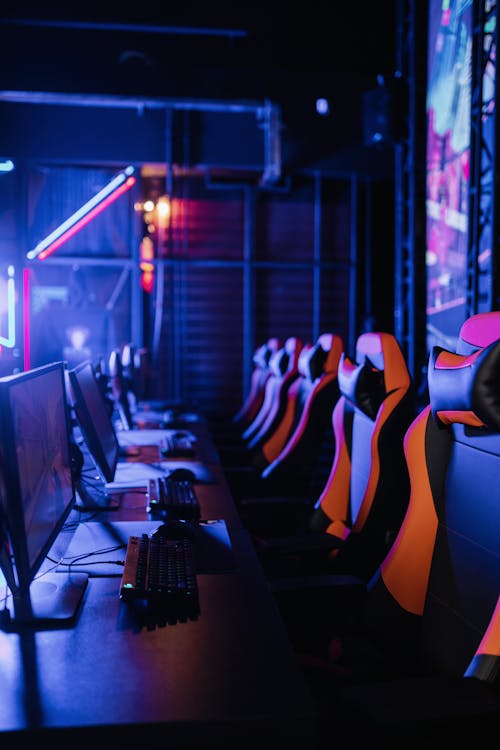Photograph of Monitors Near Gaming Chairs