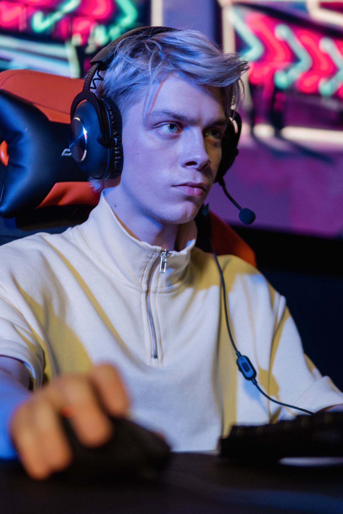 Young player wearing a gaming headset at his station