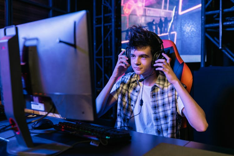 Man In Plaid Shirt Holding His Headset