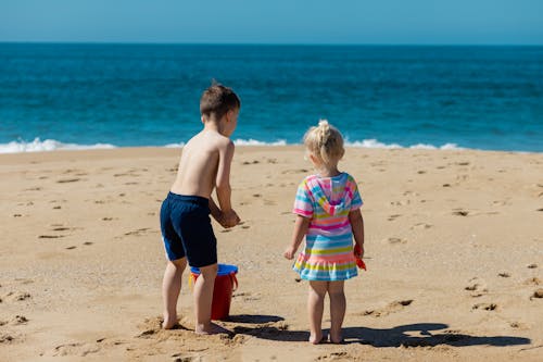 Kids Standing on Beach Sand